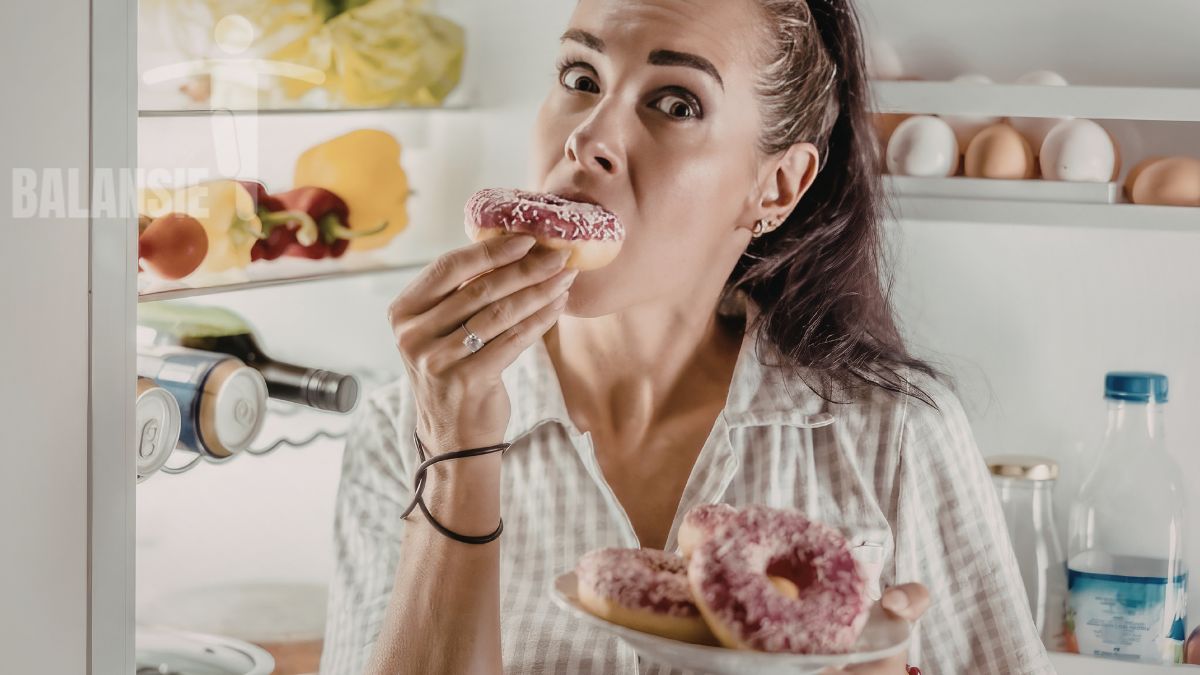 Vrouw eet uit emotie aan de keukentafel